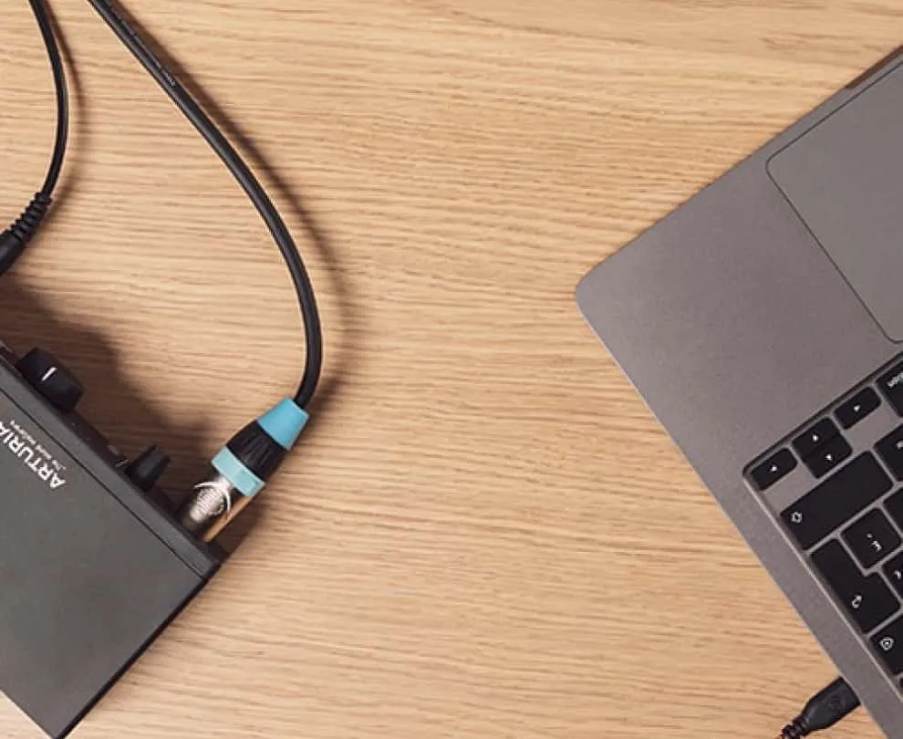 Vista parcial de una laptop Mac junto a un arturia minifuse